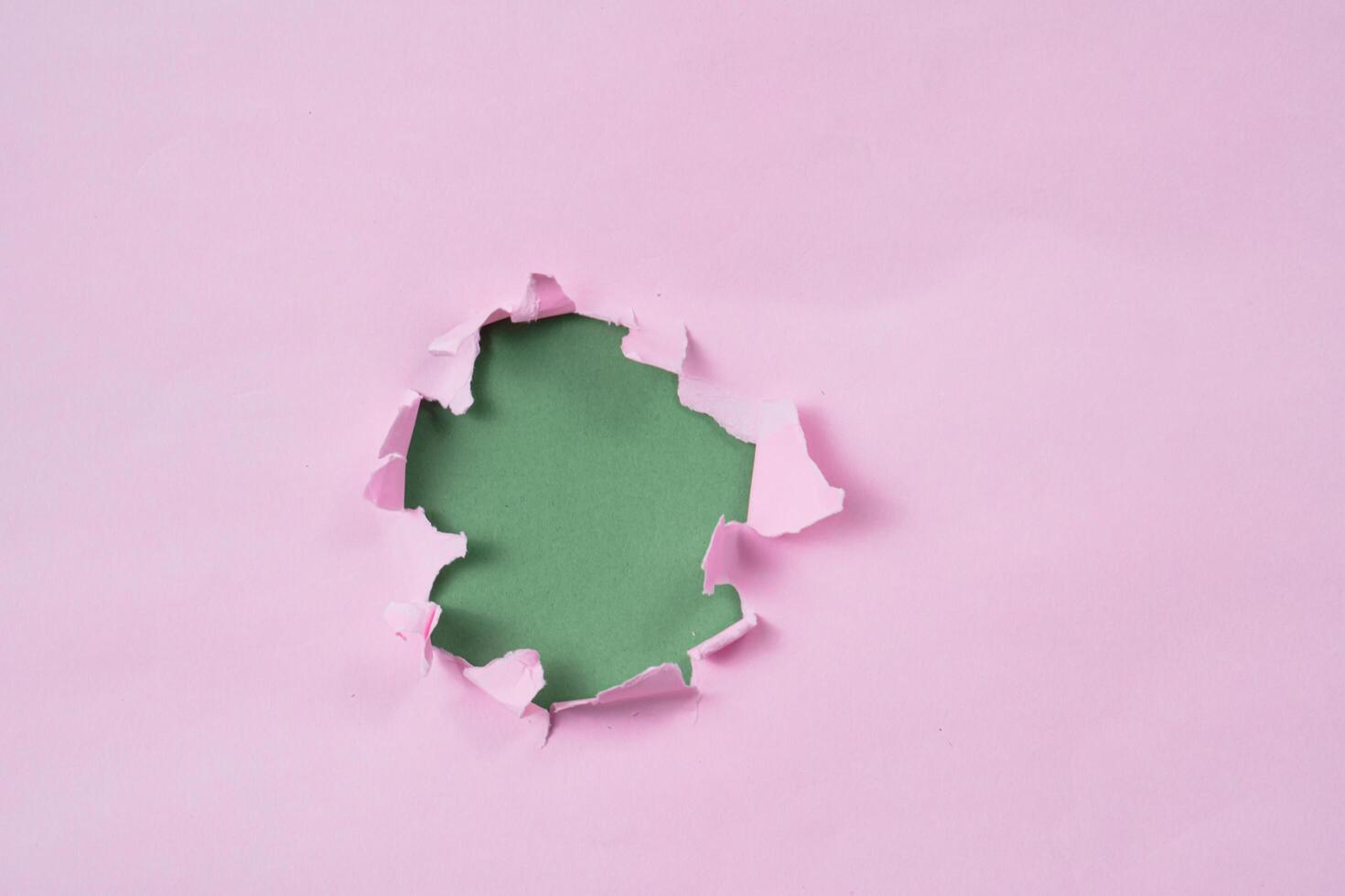 Ripped or torn pink paper frame with green copy space photo