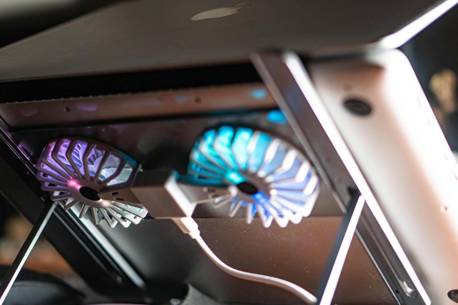 Laptop on cooling pad with illuminated fans photo