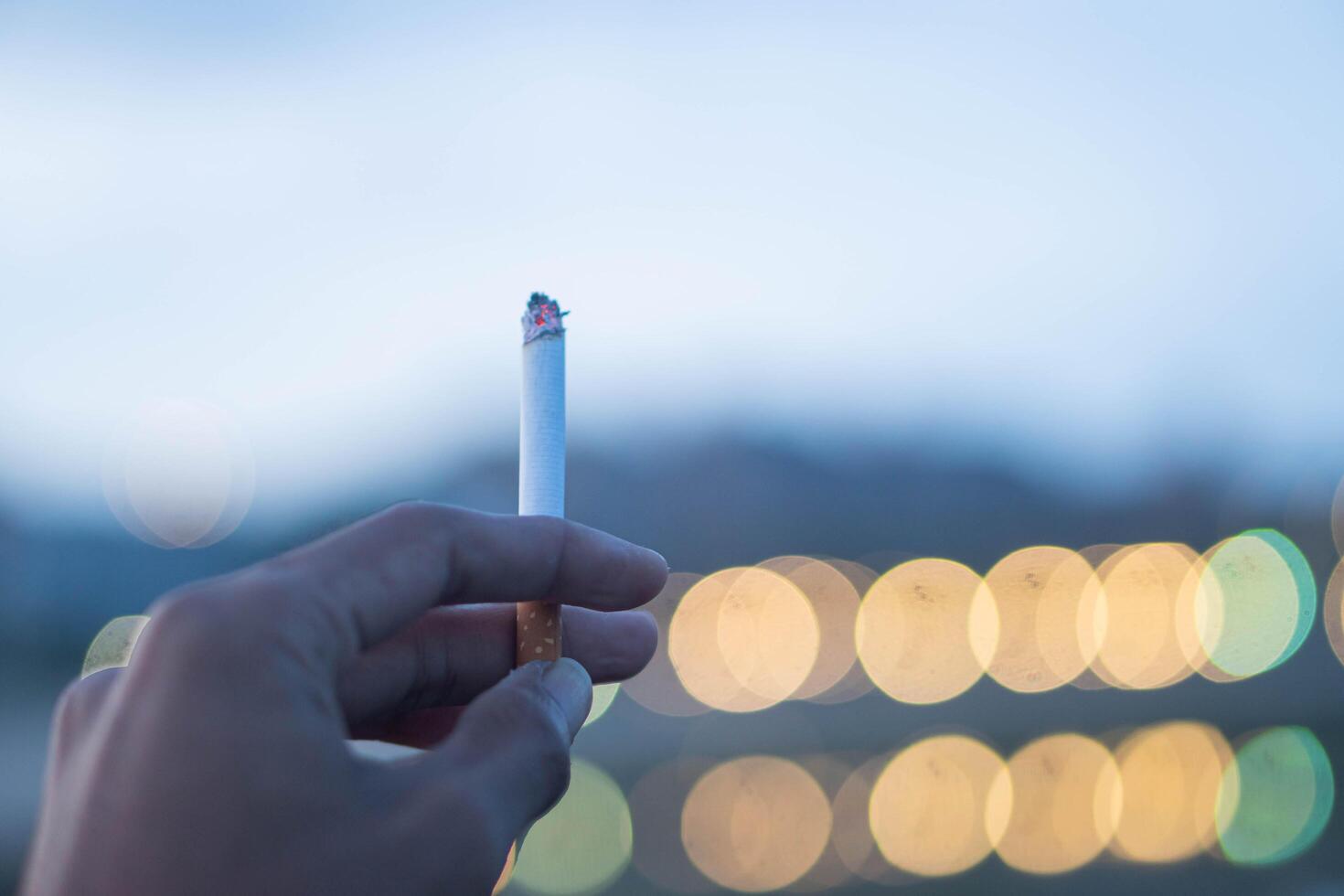 A man with a cigarette enjoys smoking photo