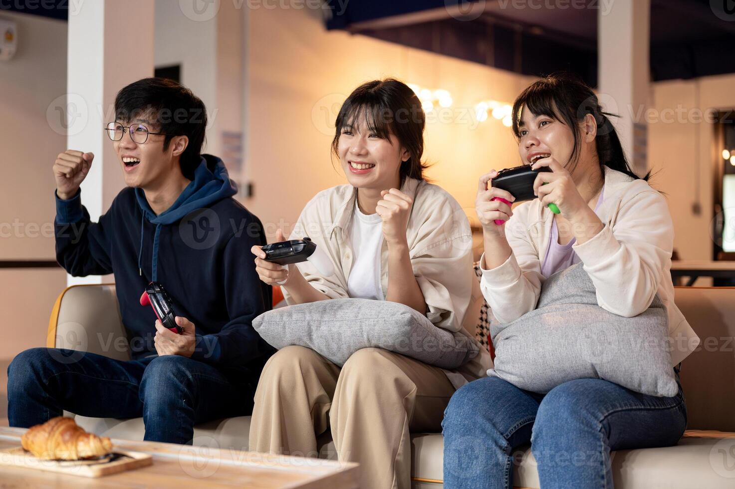 A group of young, cheerful Asian friends is enjoying playing a game together at home. photo