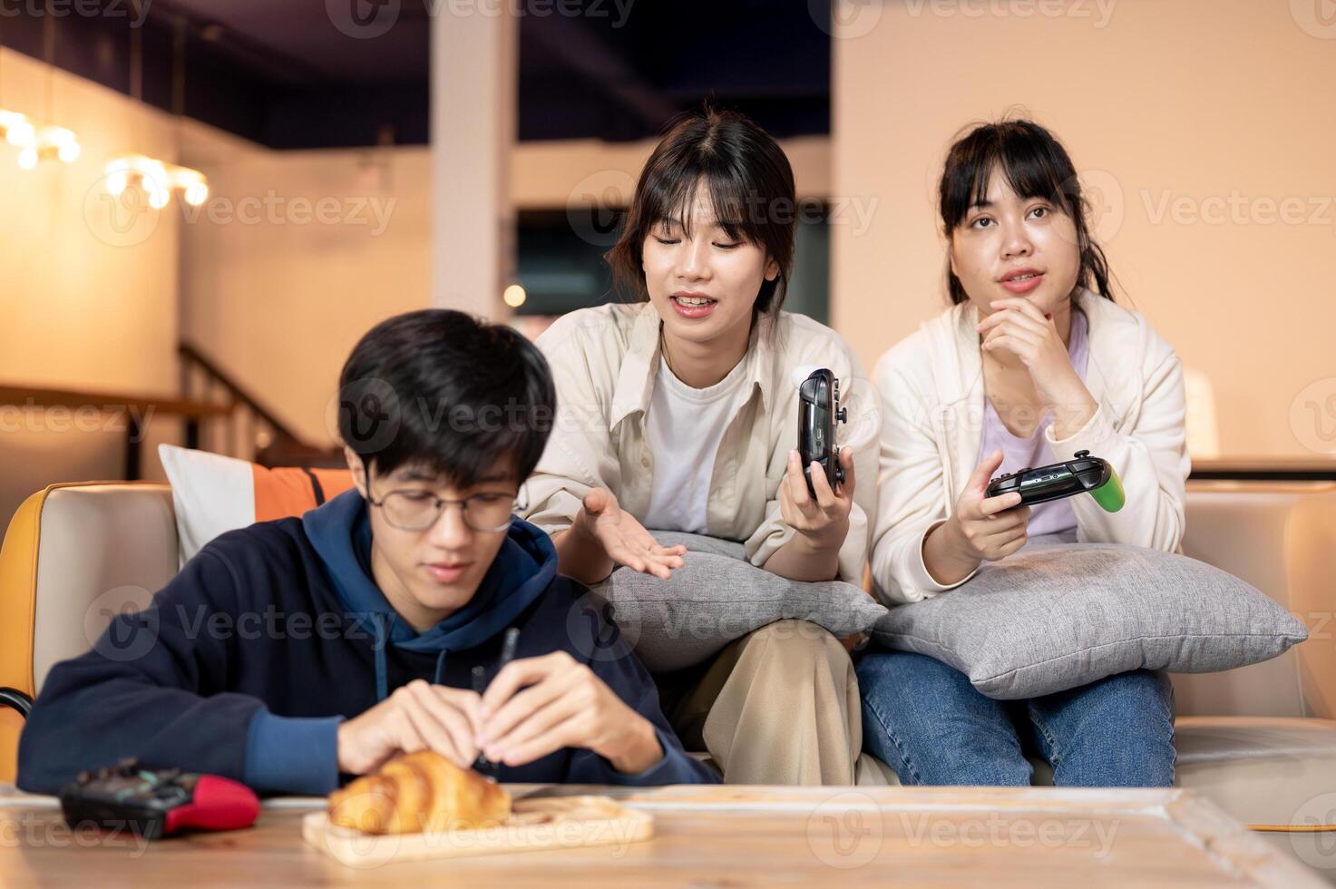 A group of cheerful Asian friends are having a fun time together at home, playing games. photo