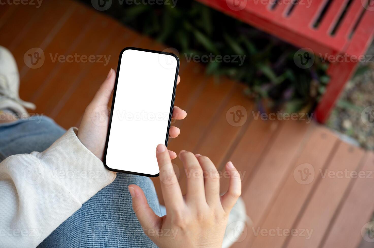 A woman is sitting indoors and using her smartphone. People and technology concepts photo