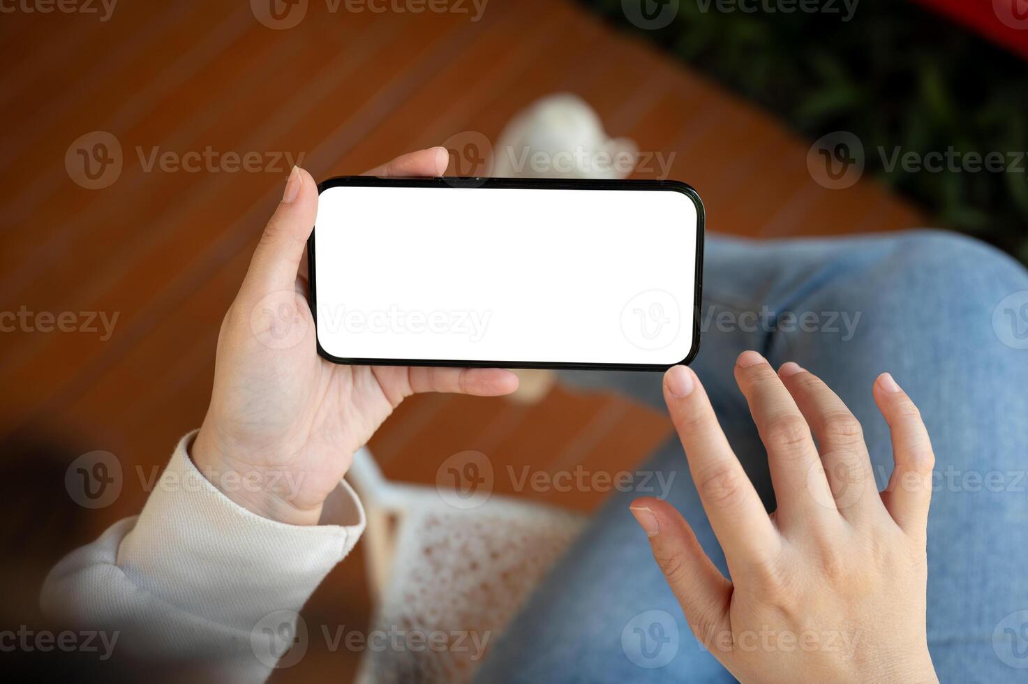 Close-up image of a woman is watching something on her smartphone while relaxing indoors. photo