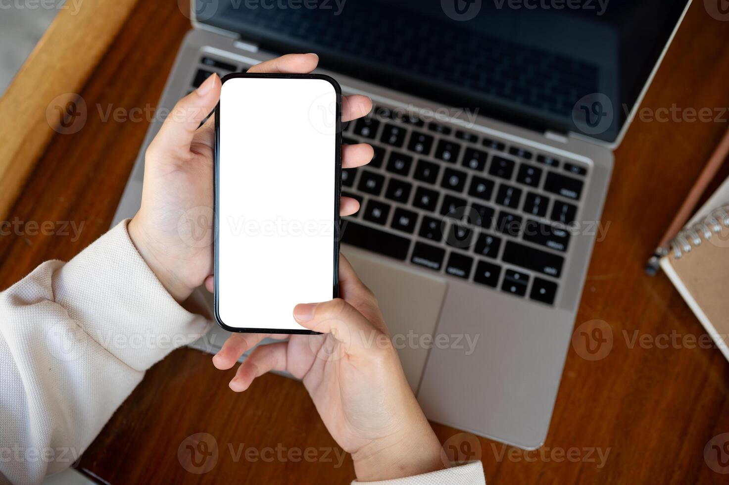 Top view image, A woman using her smartphone at a desk. A white-screen smartphone mockup. photo