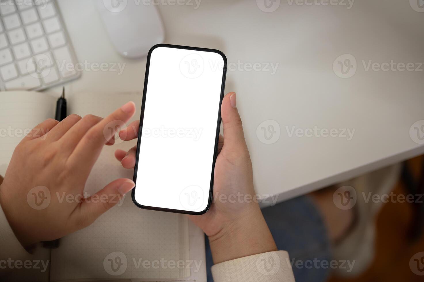 Top view image of a woman is using her smartphone at her desk. A white-screen smartphone mockup. photo