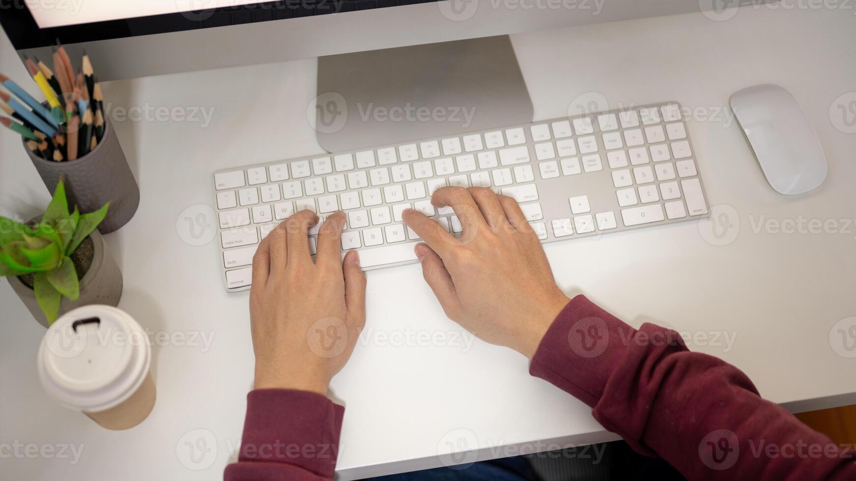 Top view image of an office man is working at his desk, typing on computer keyboard. photo