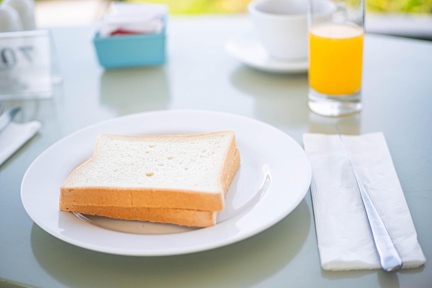 White bread slices with orange juice on breakfast table photo