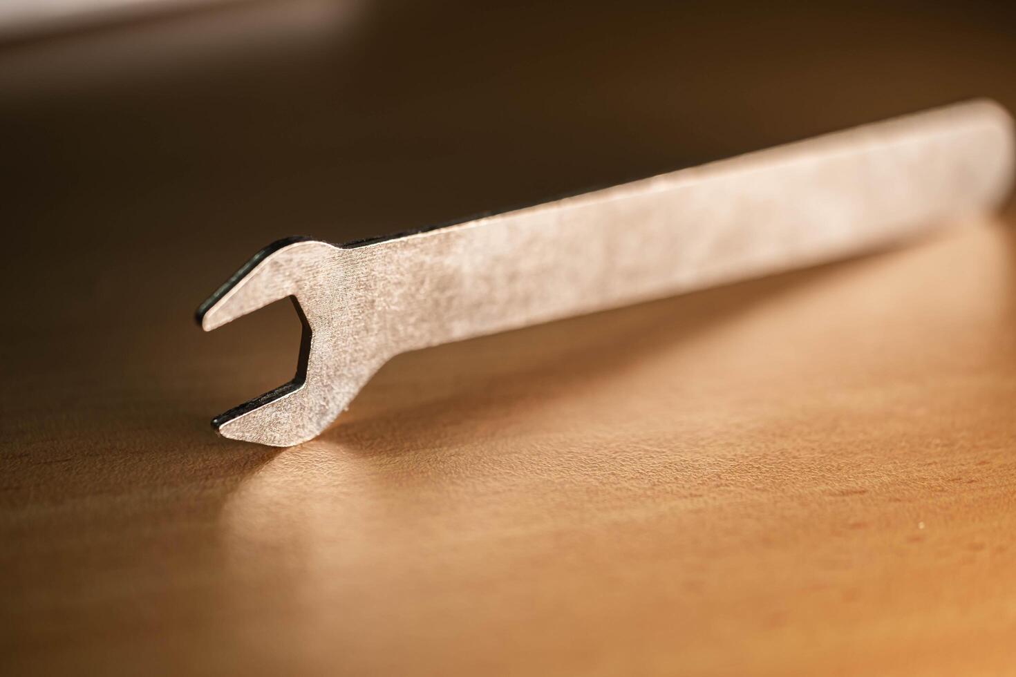 A detailed close-up of a silver crowbar resting on a wooden surface photo