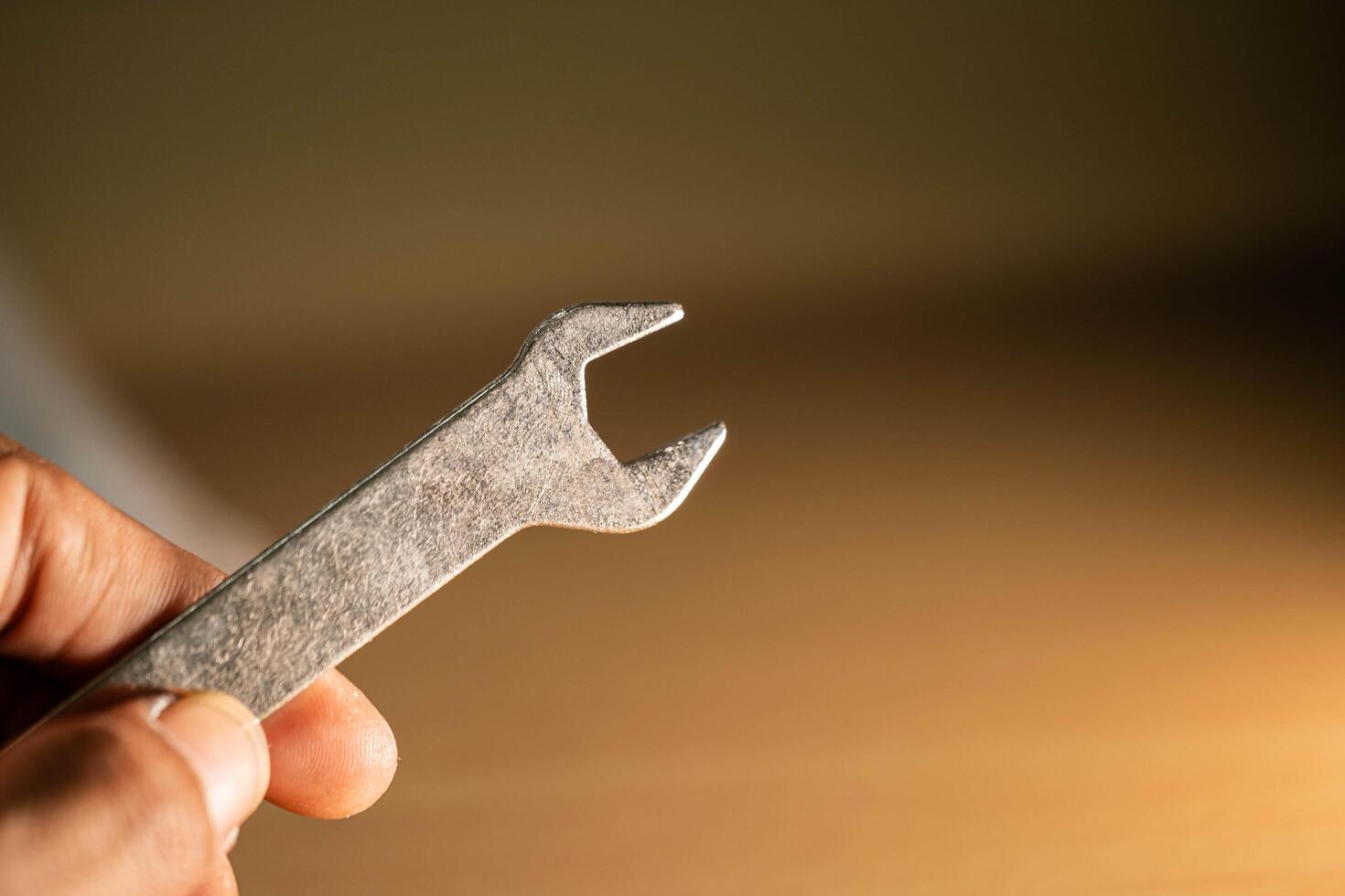 A detailed close-up of a silver crowbar resting on a wooden surface photo