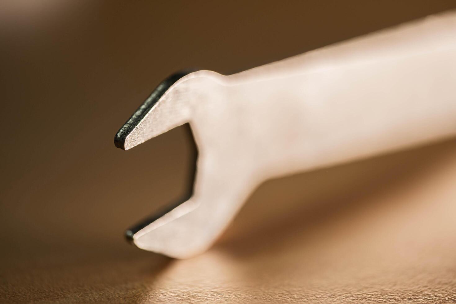 A detailed close-up of a silver crowbar resting on a wooden surface photo