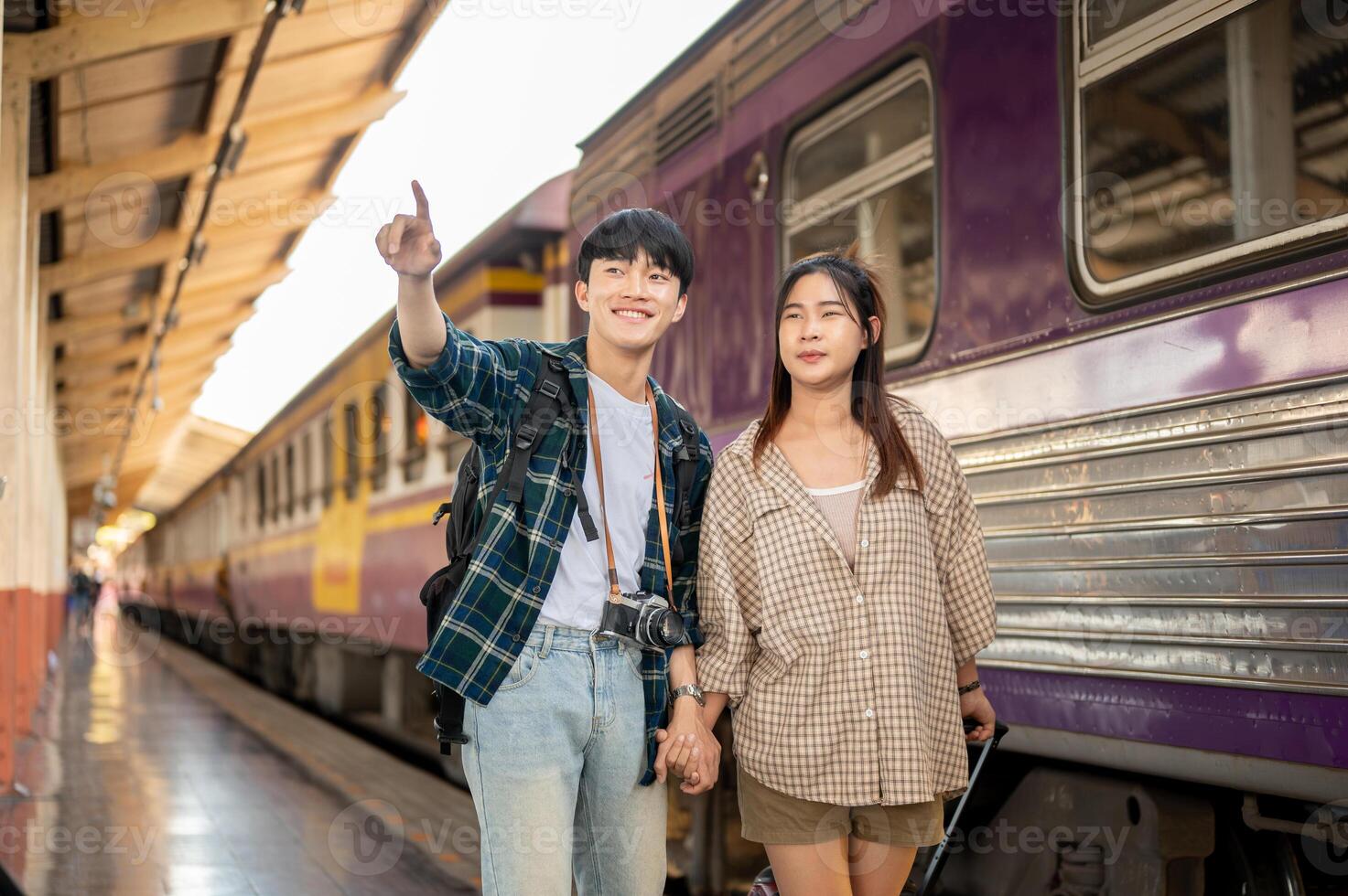 Asian couple travelers are commuting by train together, walking on a platform at a railway station. photo