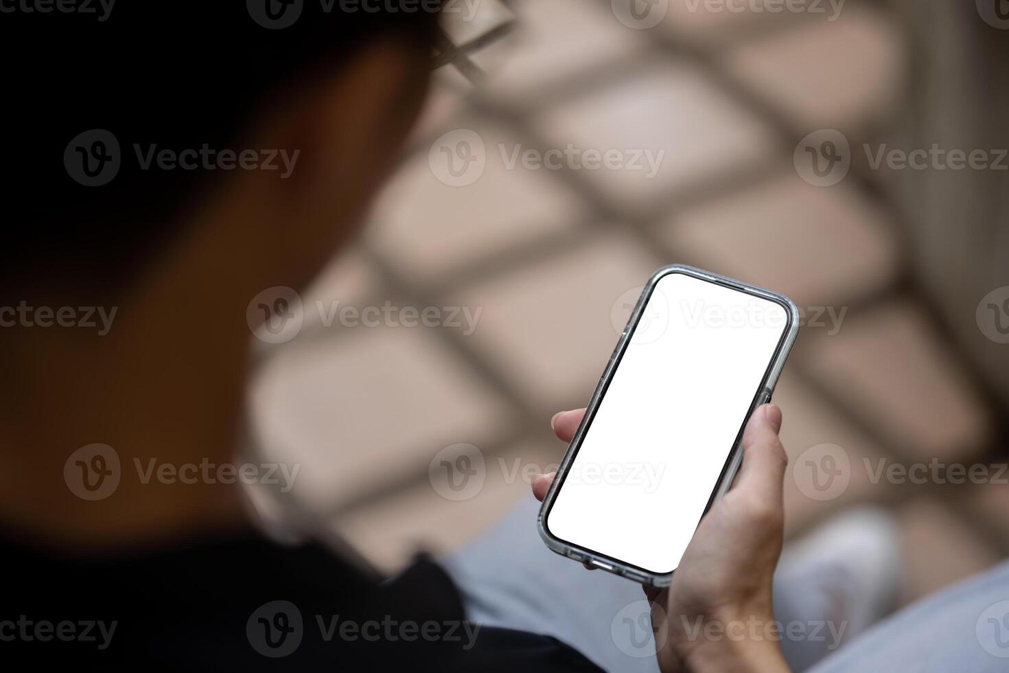 Close-up image of a man using his smartphone while sitting outdoors. People and technology concepts photo