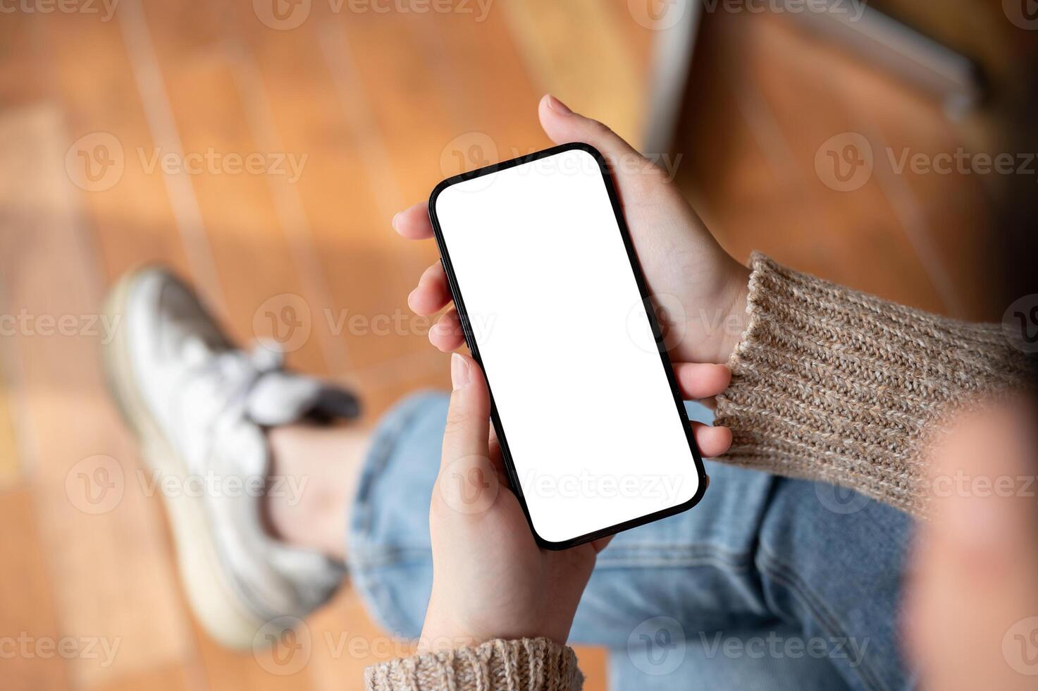 A woman using her smartphone while sitting indoors, chatting or reading an online blog. photo