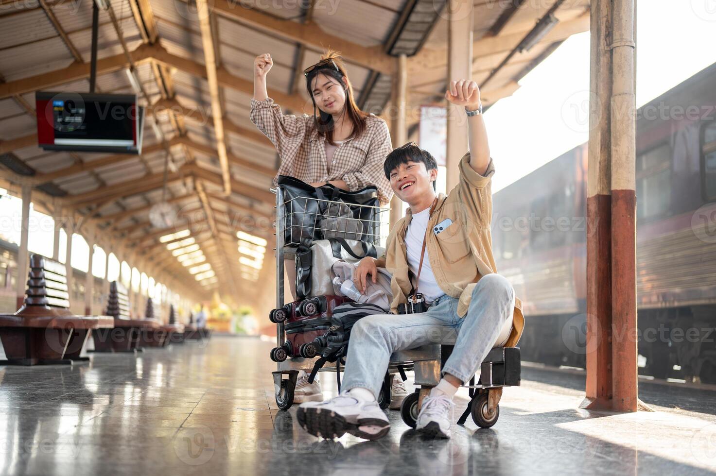 Lovely Asian couple are excited for their summer vacation, commuting by a train at a railway station photo