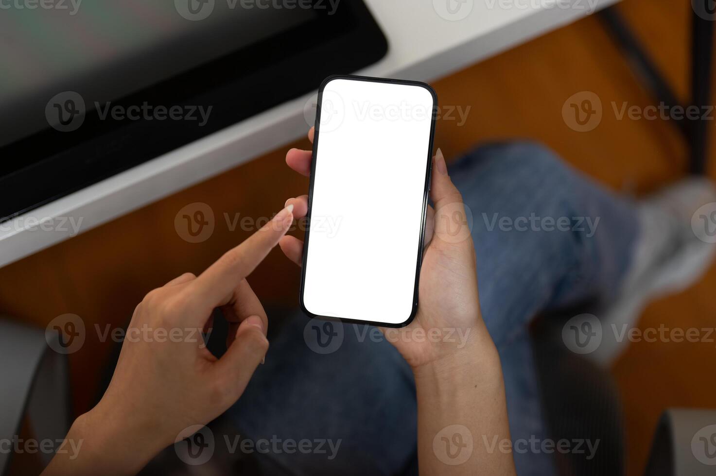 Top view image of a woman using her smartphone in the office. A white-screen smartphone mockup. photo