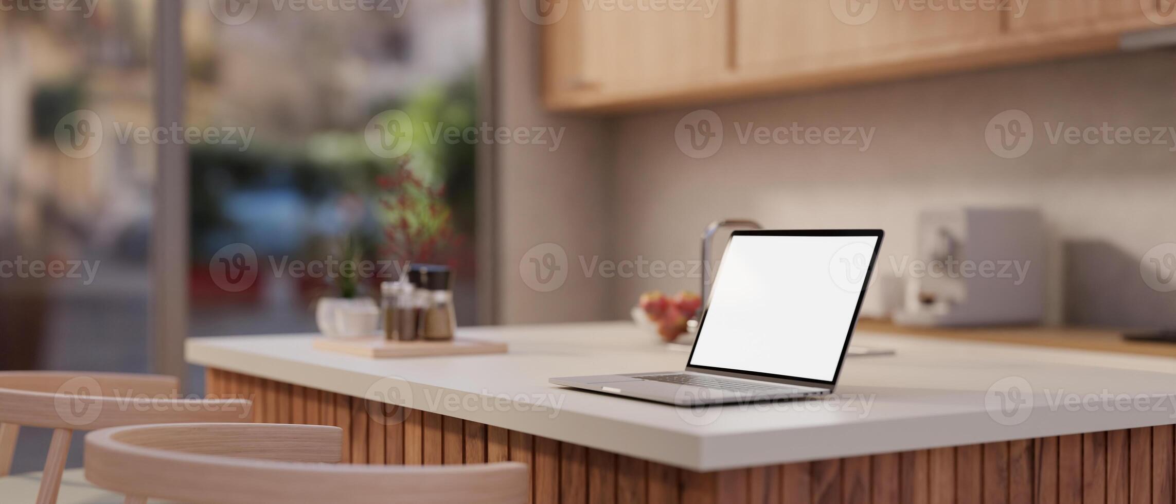 A side-view image of a white-screen laptop on a kitchen island in a modern, minimalist kitchen. photo