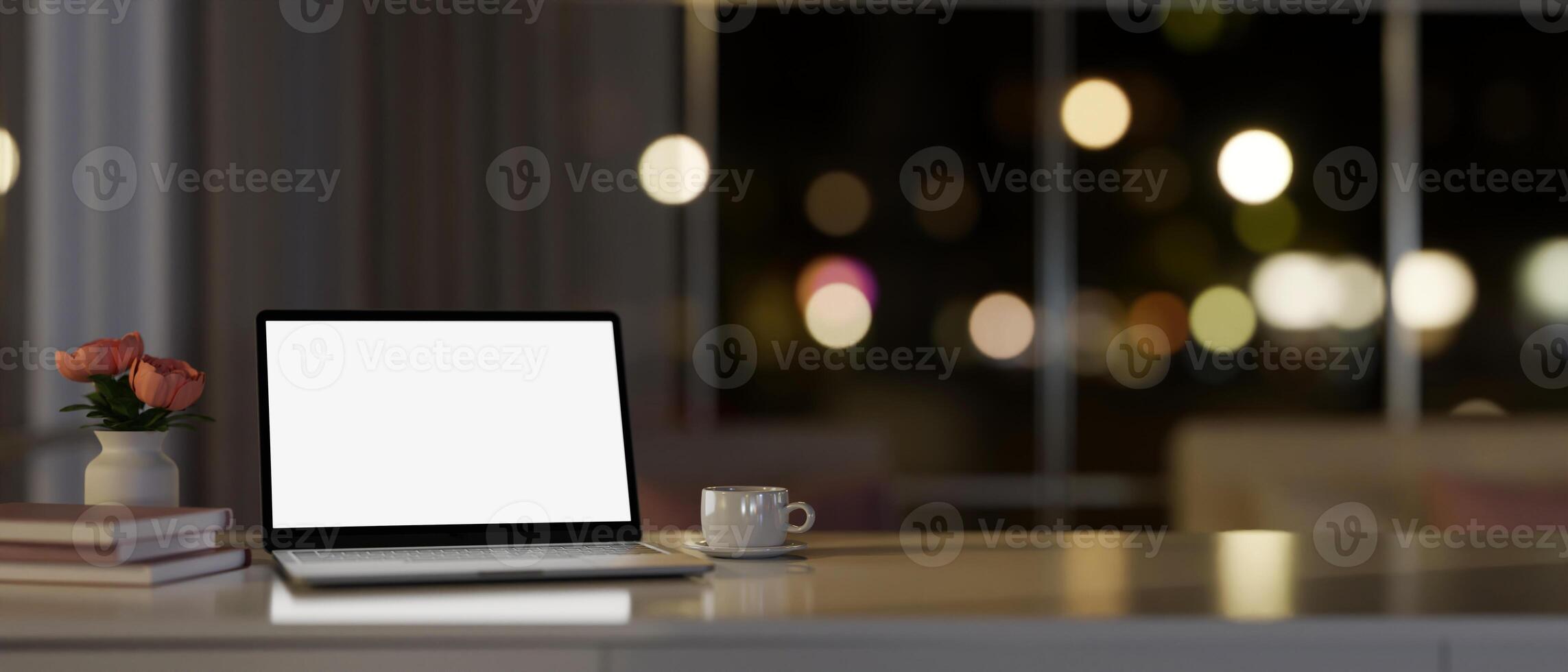 Modern apartment living room at night with a white-screen laptop computer and accessories on a table photo