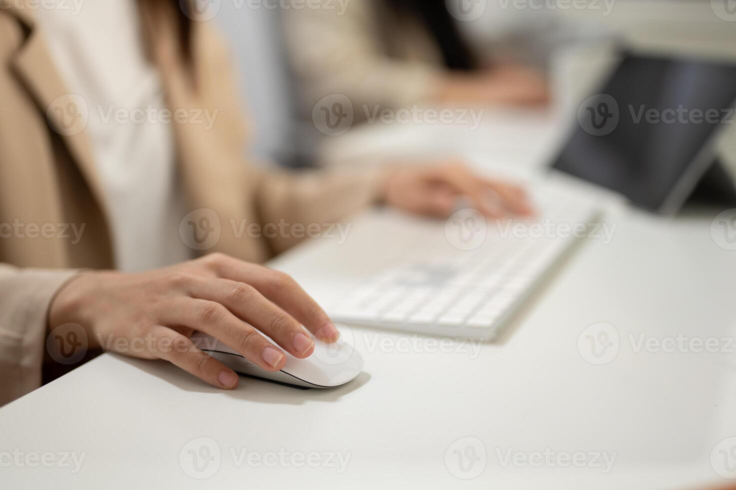 Close-up hand image of a businesswoman working at her desk in the office, using a wireless mouse. photo