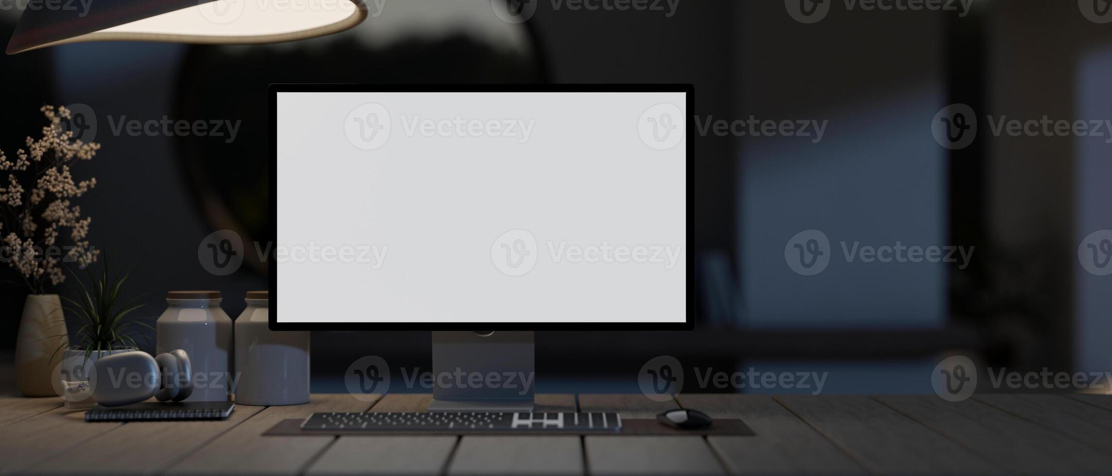 A white-screen computer mockup on a wooden plank table in a modern dark room at night. photo