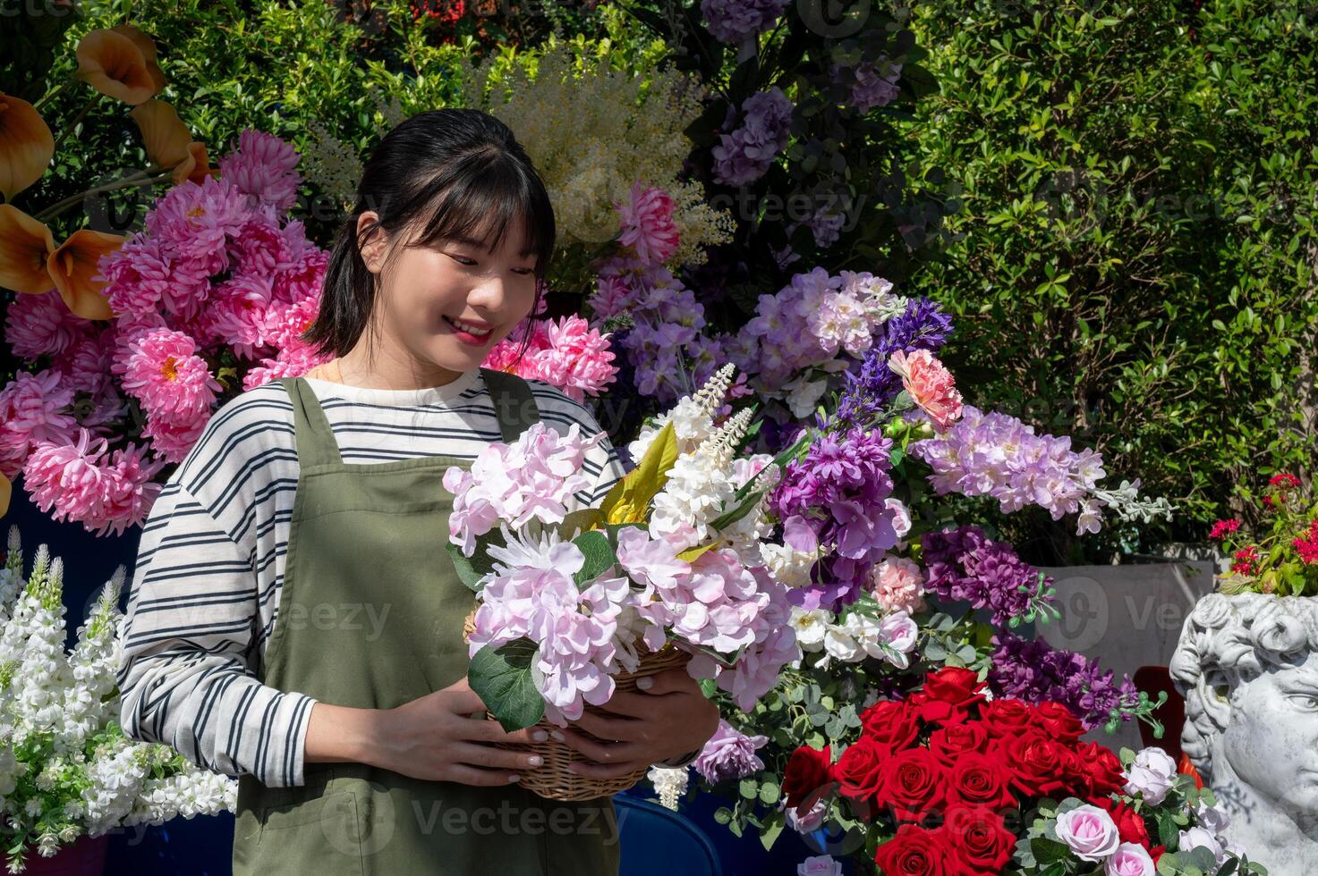 An attractive Asian female florist with a beautiful bouquet in front of her flower shop. photo