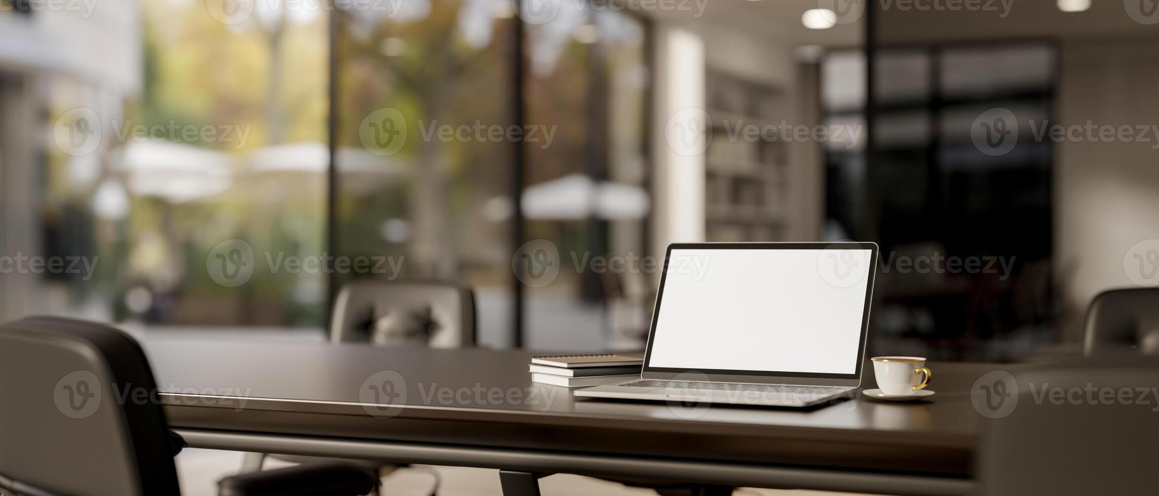 A laptop computer white-screen mockup on a meeting table in a modern meeting room. photo