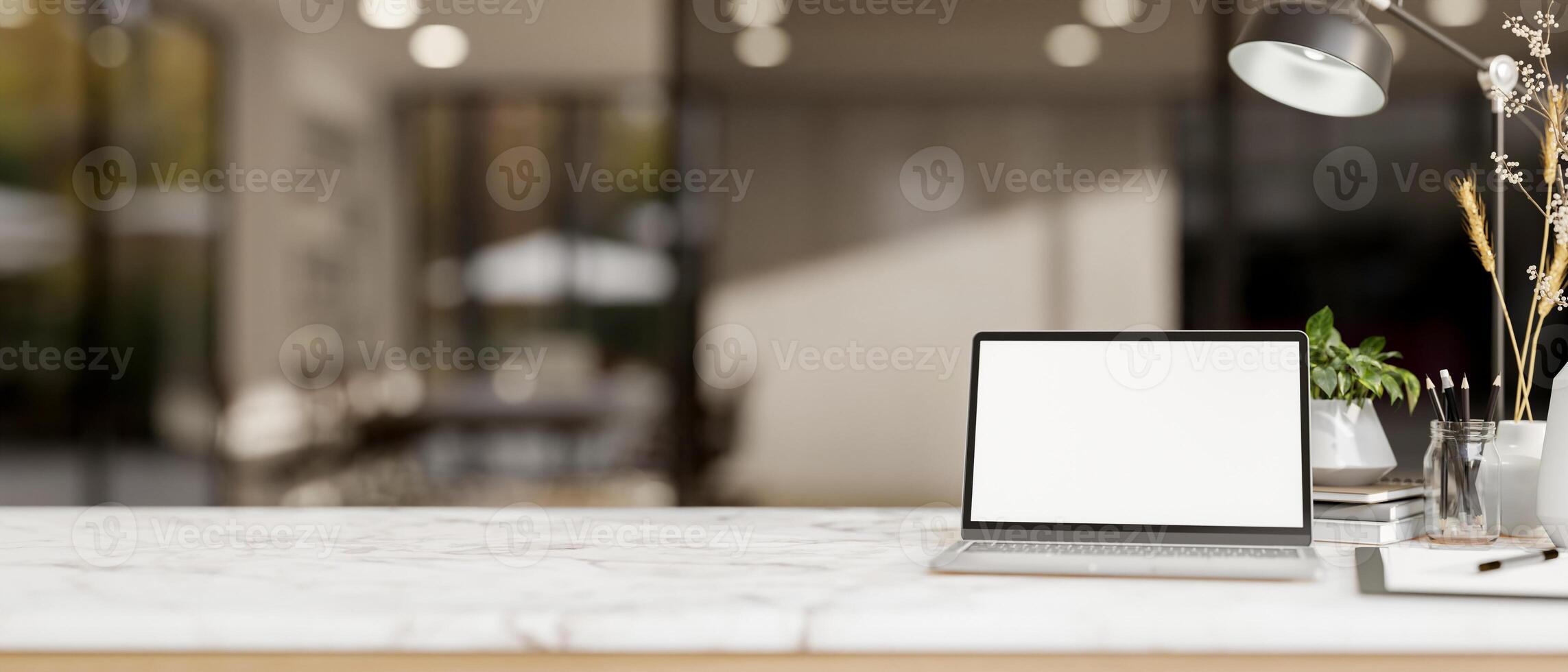 A white marble tabletop features a white-screen laptop computer in a modern office corridor. photo