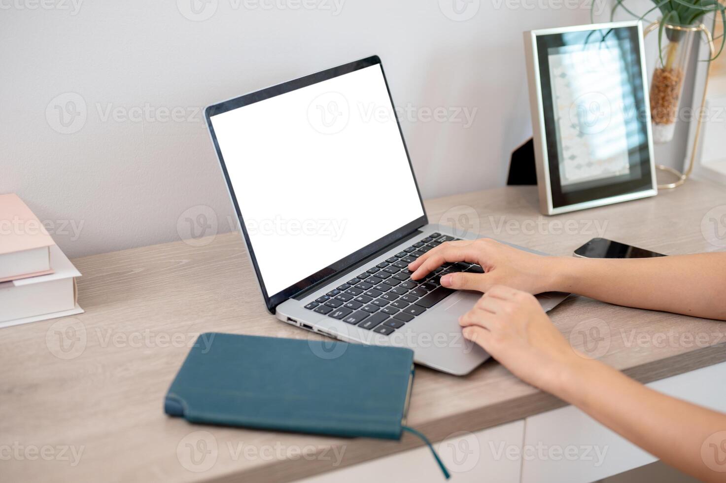 A close-up hand image of a woman working on her laptop computer, typing on the laptop keyboard. photo