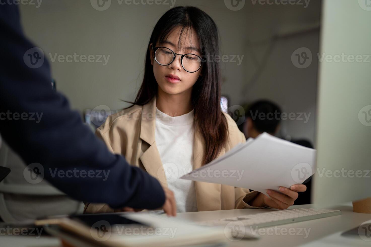 A serious Asian businesswoman is concentrating on co-working with her colleague in the office. photo