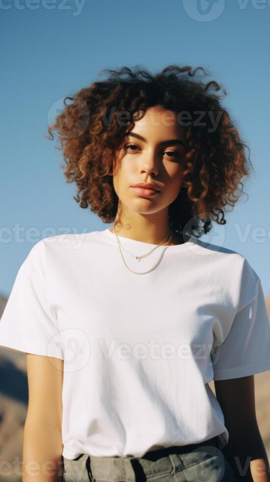 A beautiful girl in a white T-shirt against the background of a beautiful landscape. . photo