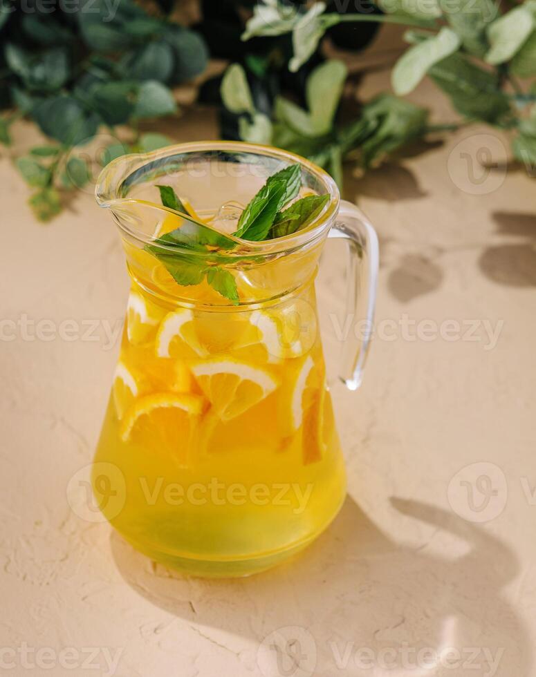 Fresh citrus lemonade in glass pitcher with mint photo