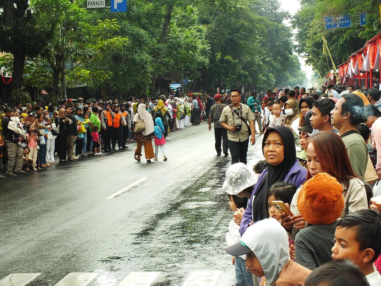Surakarta City, Central Java, Indonesia, May 15, 2024. Crowd people watching a parade at Slamet Riyadi Street. photo