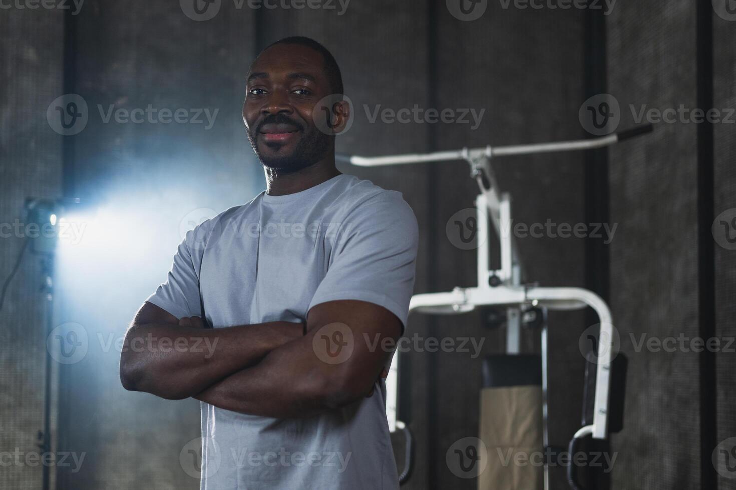 Fitness workout in gym. Portrait of African American man standing in gym with motivation health energy ready for training. Athletic coach personal trainer fitness club owner. Healthy lifestyle photo