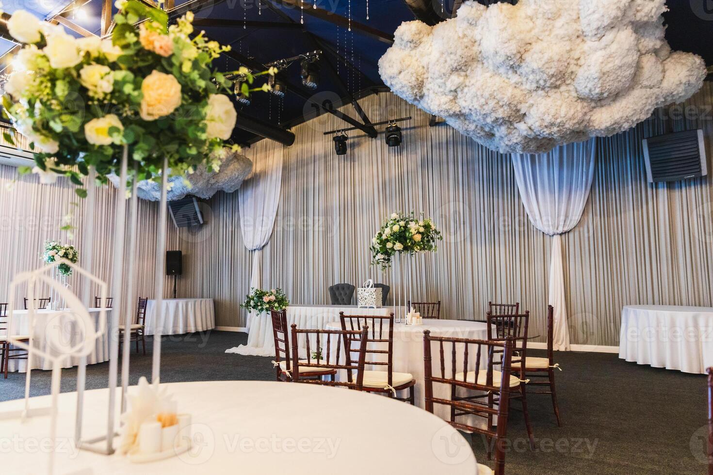 Decorated interior for festive event. Fancy table set for dinner with flower composition in restaurant, luxury interior background. Wedding elegant banquet decoration arranged by catering service photo