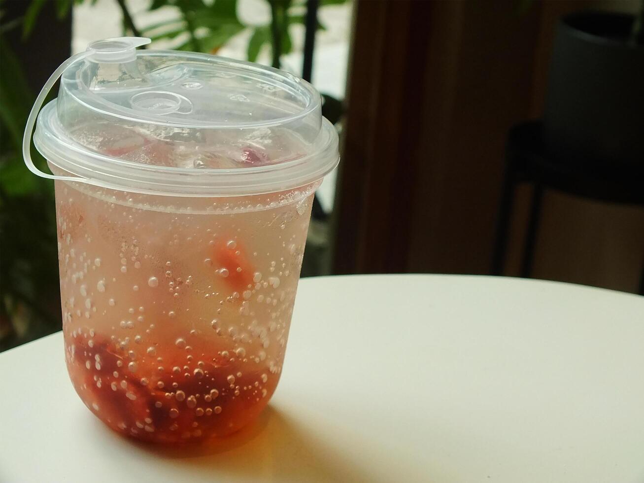 fresh and cold strawberry soda with ice isolated on blurred interior cafe shop. fresh drink for summer day. Food and beverage image for coffee shop and restaurant business photo