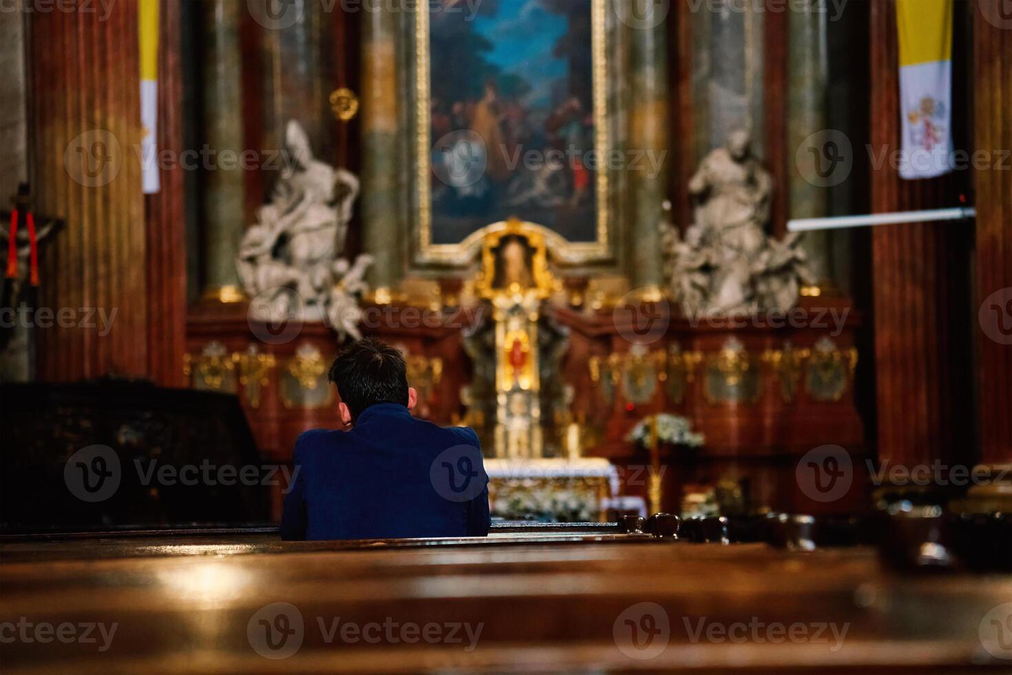 Back View of Man Praying in Catholic Church photo
