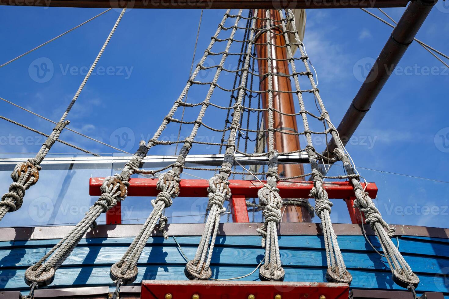 Part of an old wooden ship with ropes tied in knots and wooden fasteners. photo