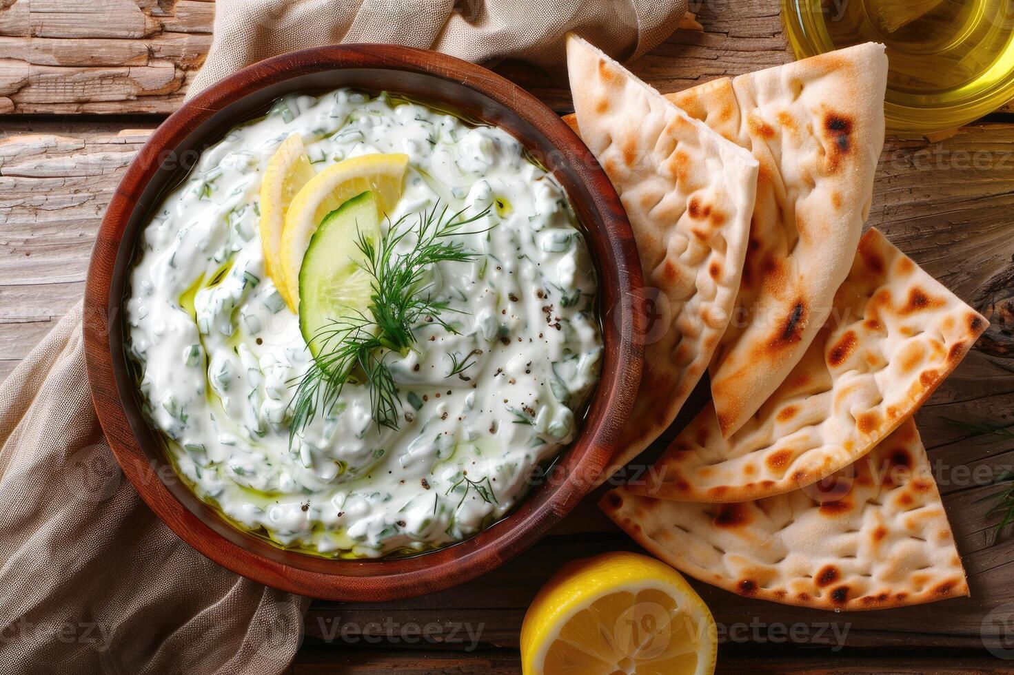 Traditional Greek Tzatziki dip sauce made with cucumber sour cream, Greek yogurt, lemon juice, olive oil and a fresh sprig of dill weed. Served with toasted Pita bread. photo