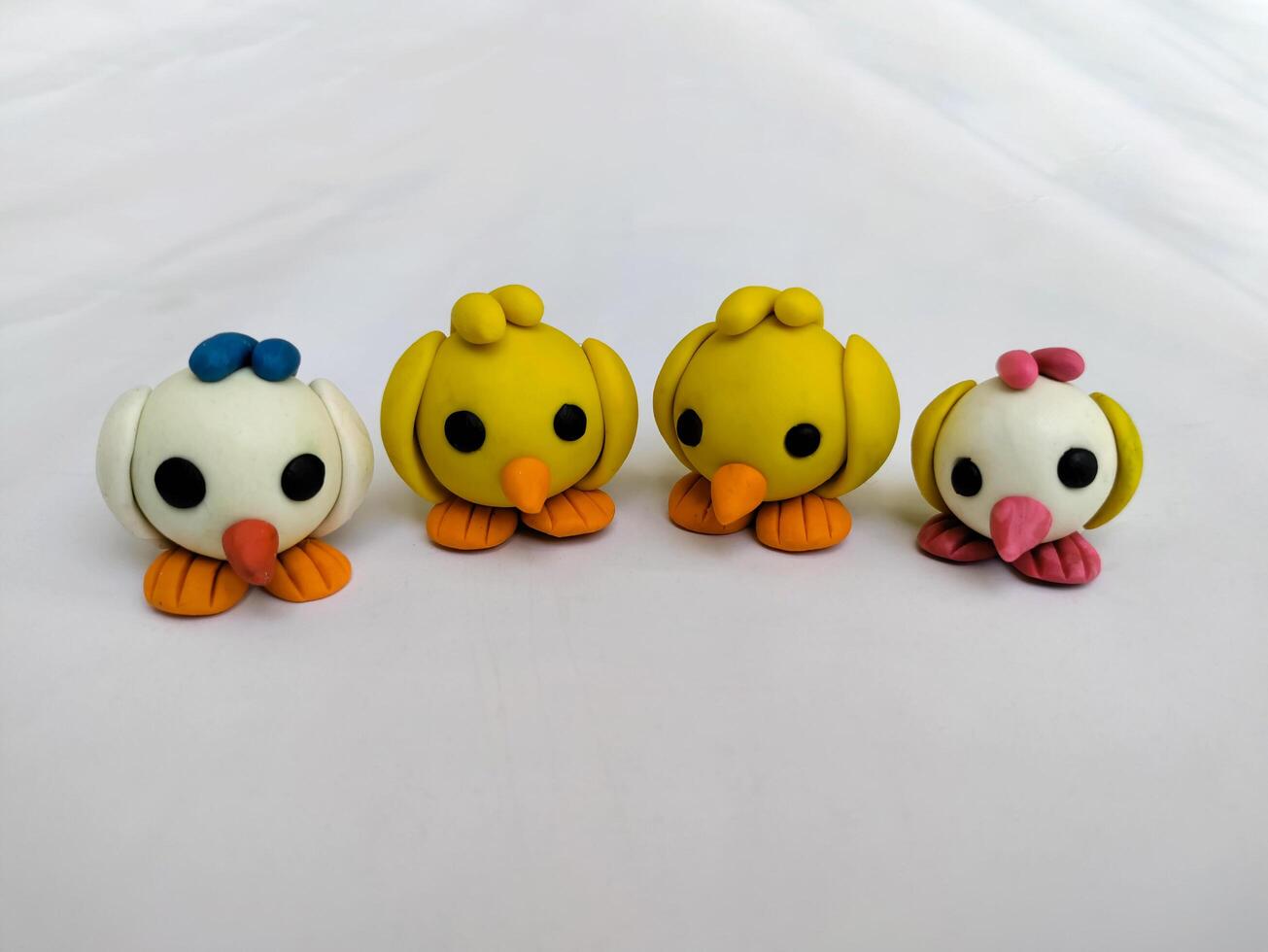 Set of Four Handmade Clay Plasticine Birds Minimalist two yellow and two whites made by dough on white background - Clay toys photo