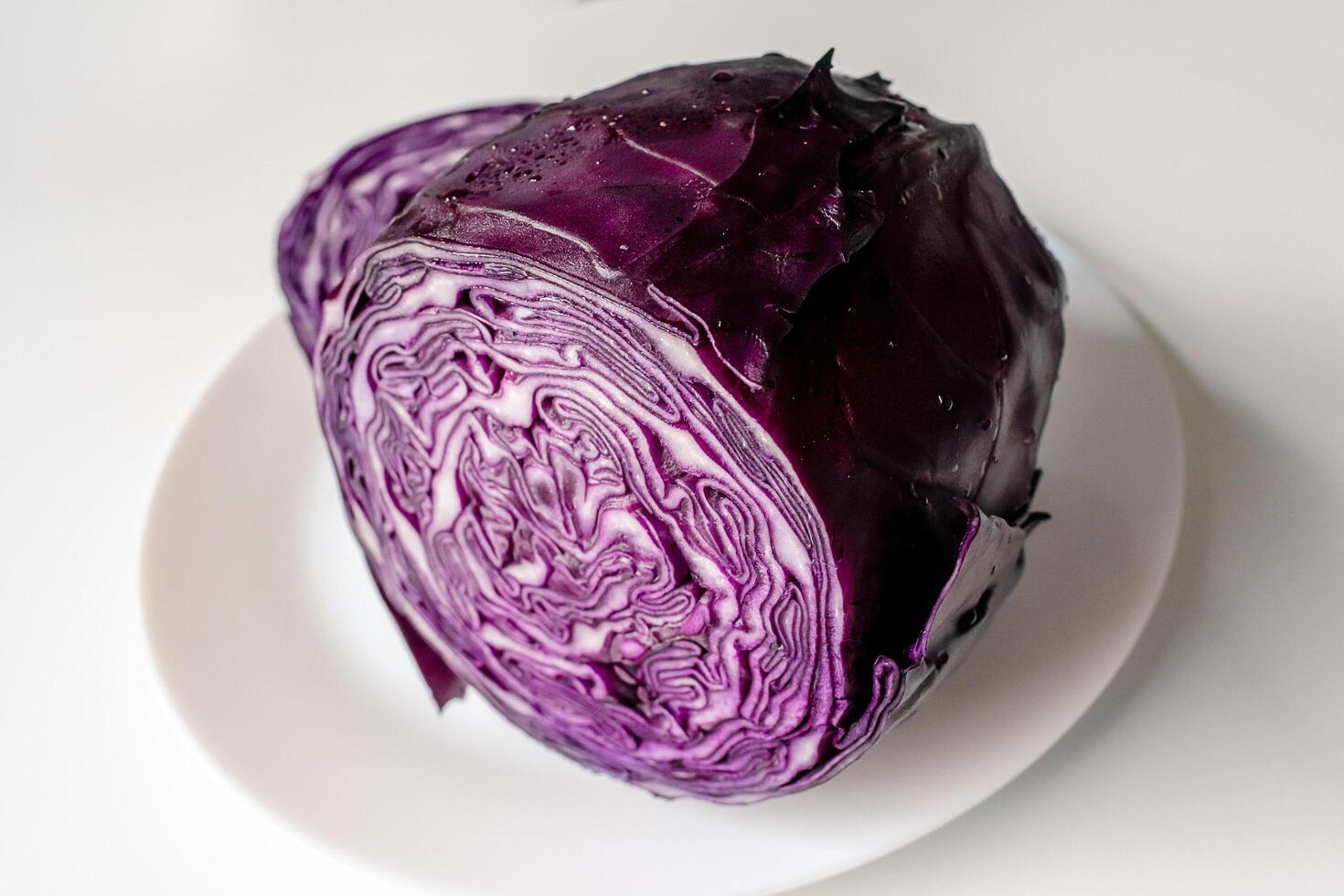 Red cabbage on a large white plate. Cut red cabbage on a white background. photo