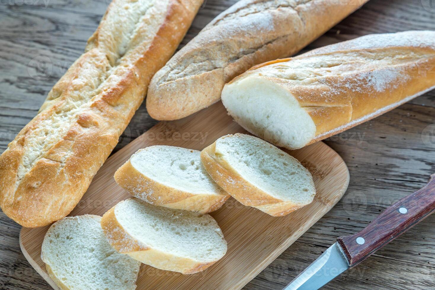 Three baguettes on the wooden background photo