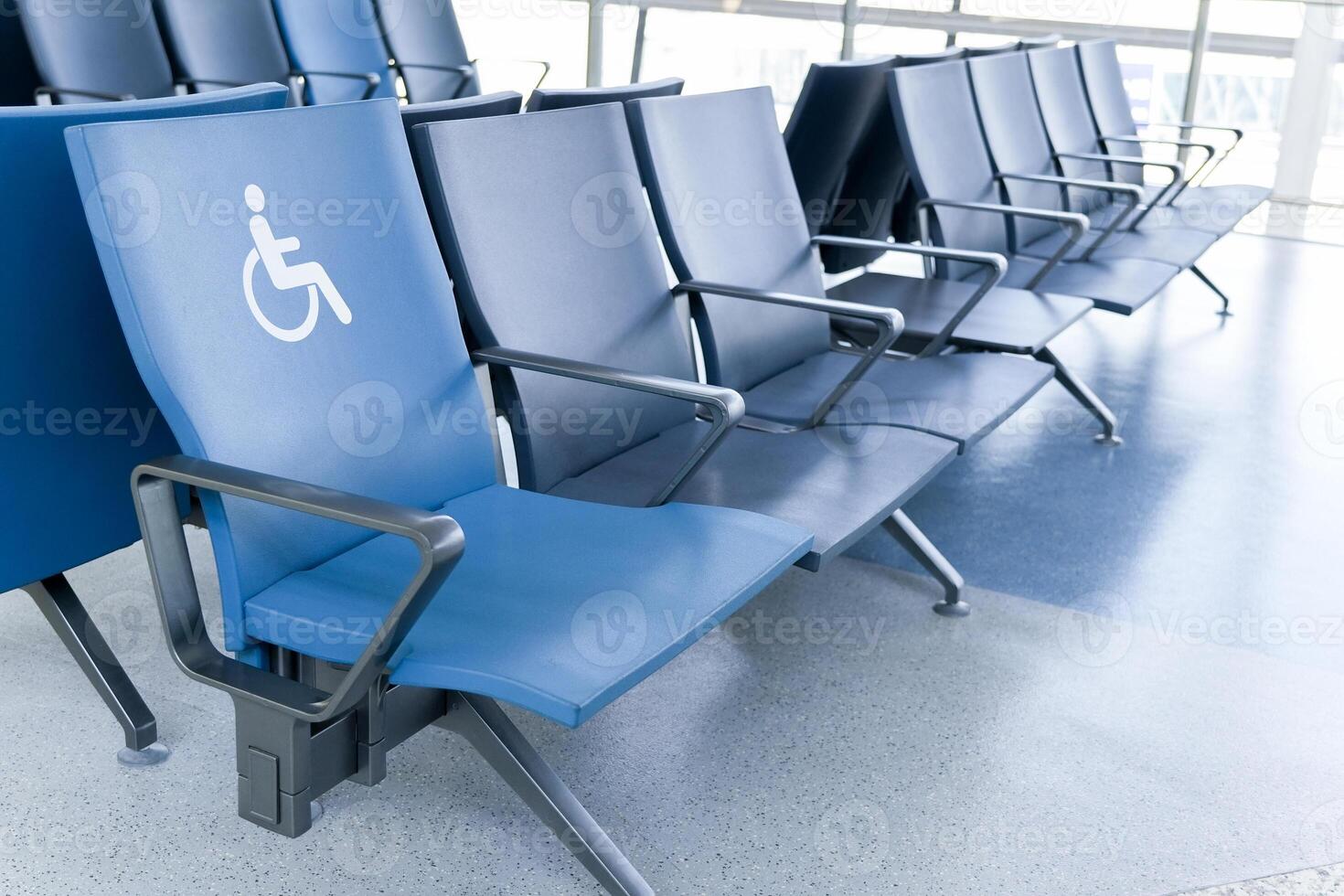 Rows of empty blue seats in public waiting area for people with physical disabilities and people with special needs photo