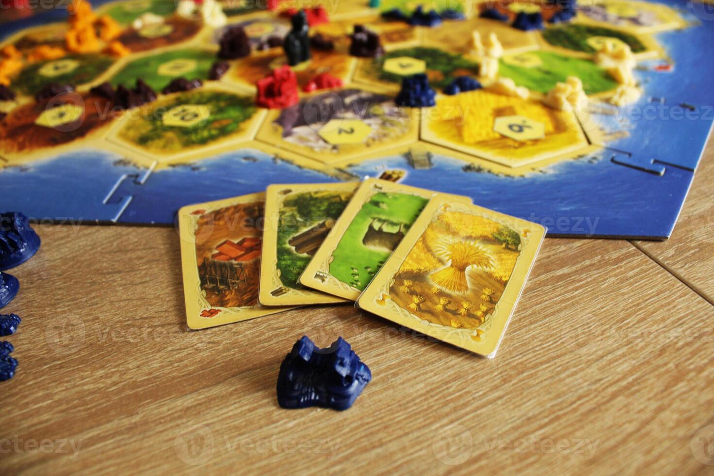 Mozyr, Belarus, April 01 2024. A catan board game buying a settlement in the game exchange the resources of hay, wheat, sheep, wood and bricks, clay for a settlement. Rules for buying and building photo