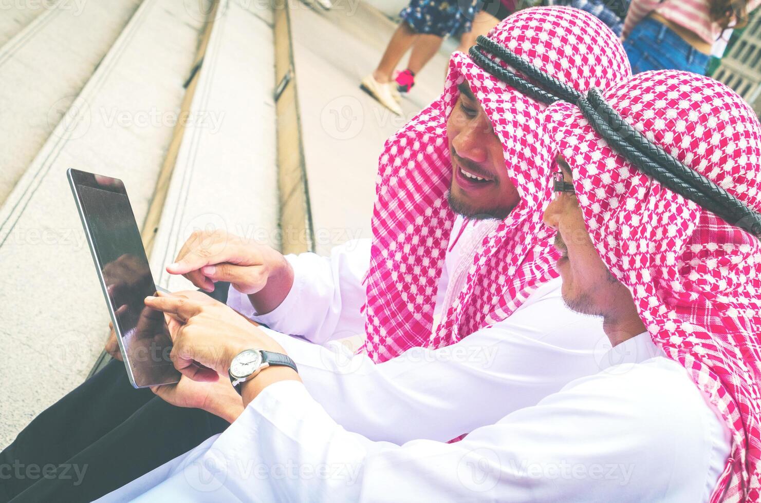 In town at staircase. Muslim businessmen play smart phone and glad.They are receive good news from internet. Photo concept business.