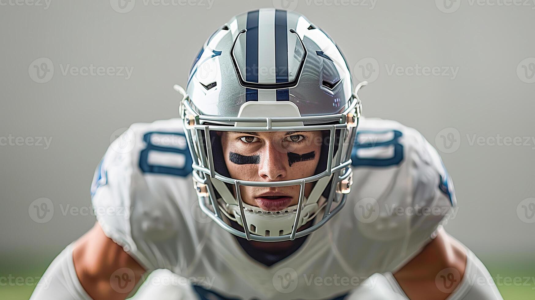 American football player in a gray helmet and white uniform stands waiting for the ball to be drawn photo
