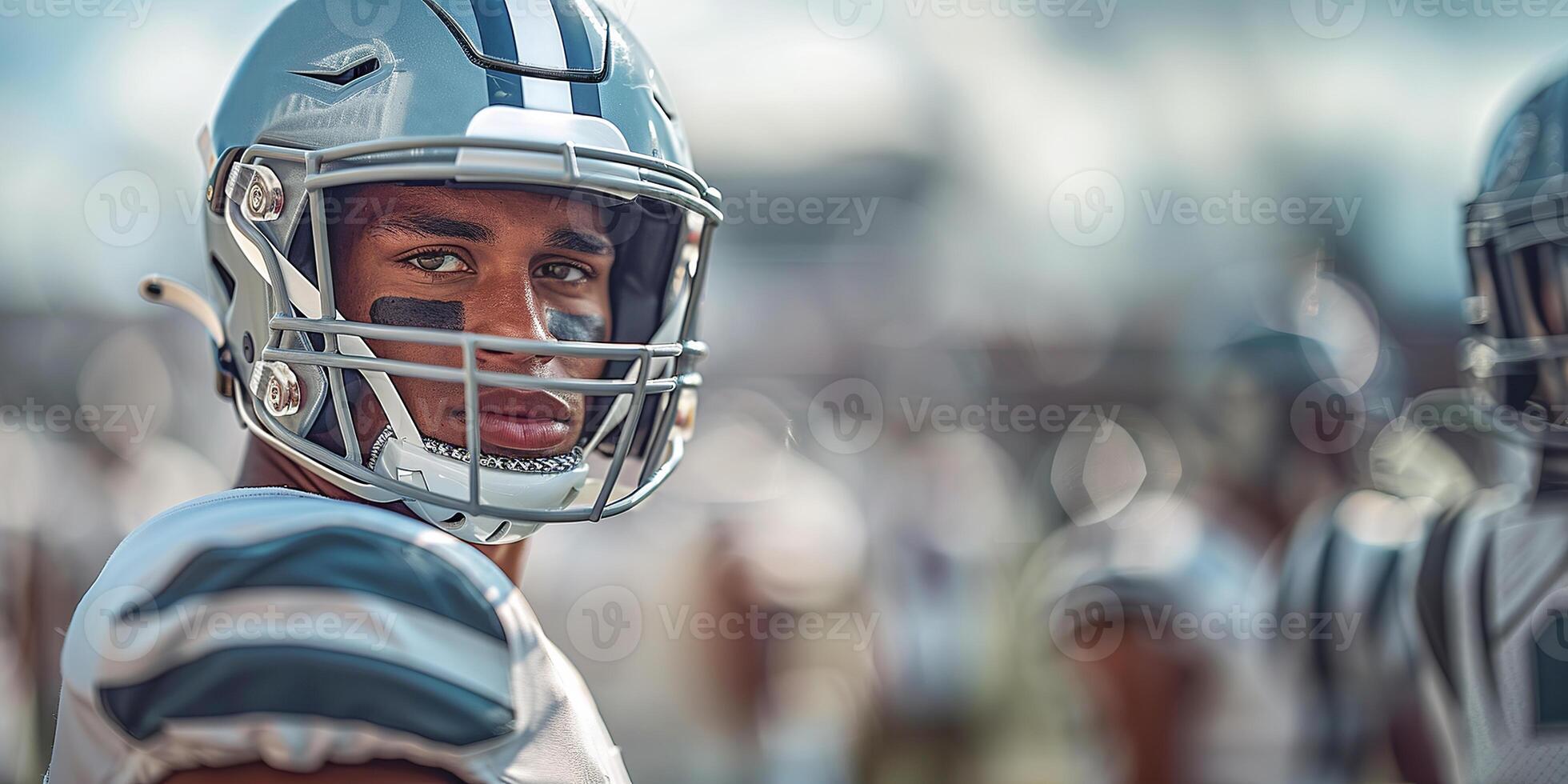 American football player in a gray helmet and white uniform turned to the right during a football match. Copy space photo