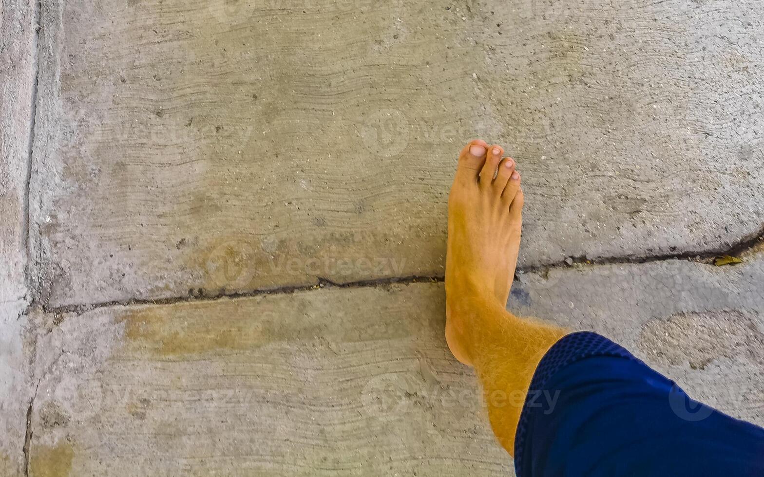 Walking on the pavement rocks stones feet barefoot in Mexico. photo
