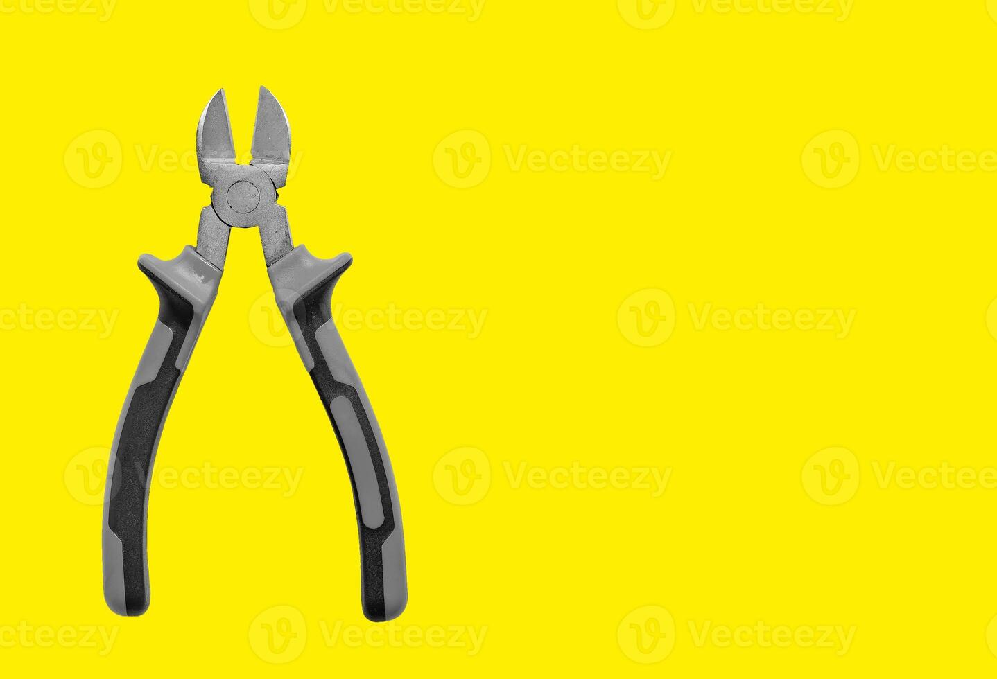 Industrial pliers, diagonal cutting tool for wire and cable. Yellow background with copy space, photo