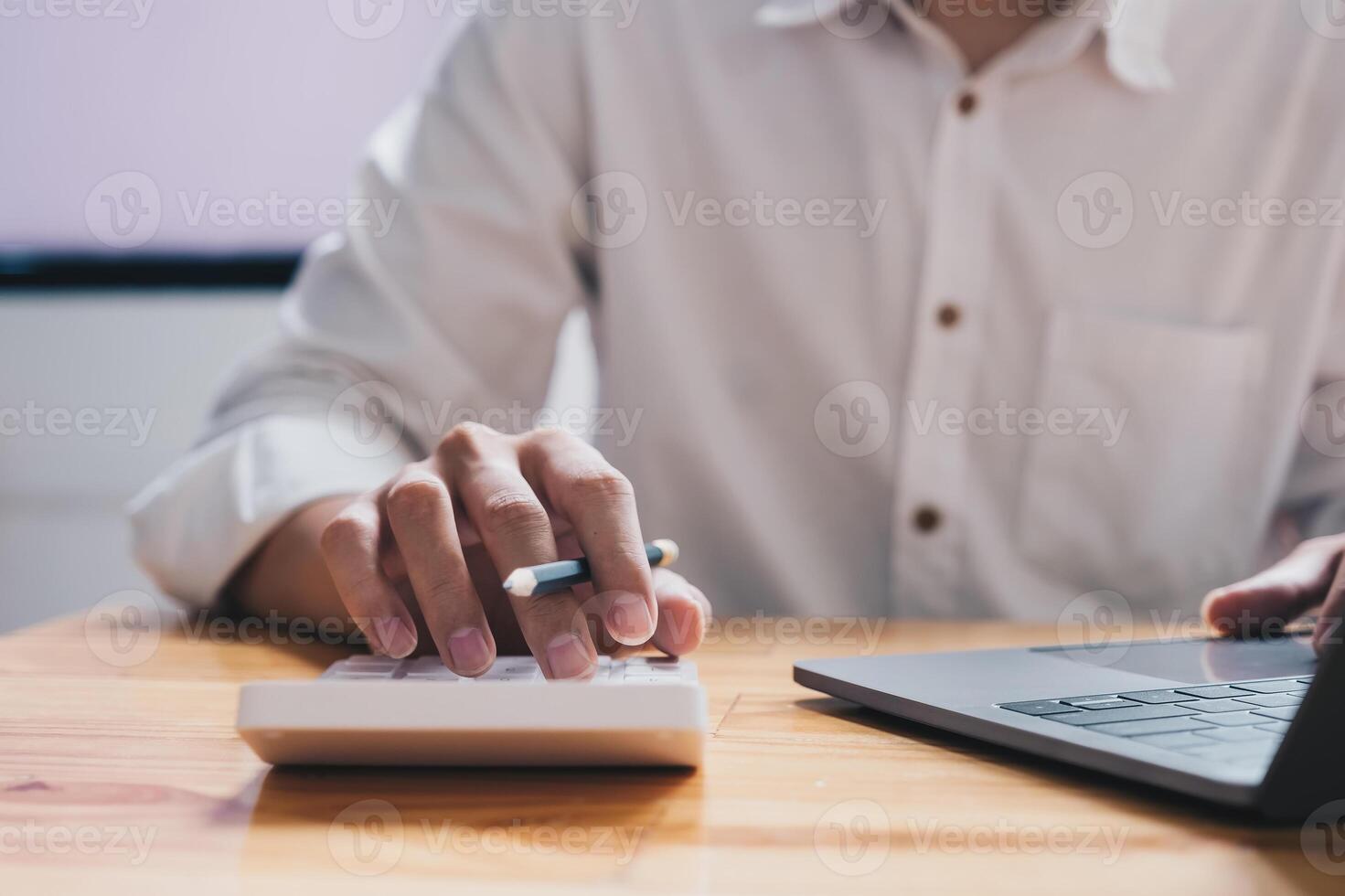 Close up a man working about financial with calculator at his office to calculate expenses, Accountigng concept photo