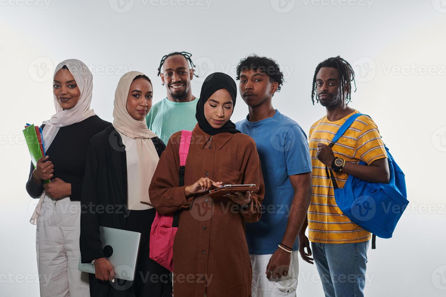 Group of diverse students engages in modern educational practices, utilizing a variety of technological tools such as laptops, tablets, and smartphones against a clean white background, exemplifying photo