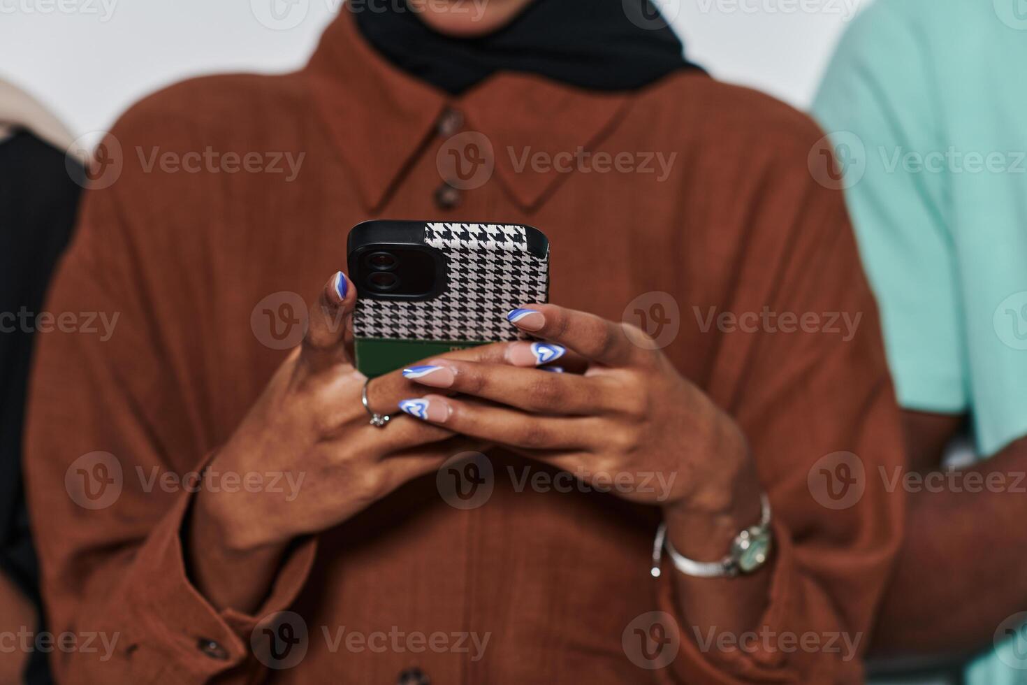 Captured in a close-up moment, a girl in hijab skillfully engages with her smartphone, reflecting a contemporary lifestyle where digital connectivity seamlessly intertwines with cultural expression photo